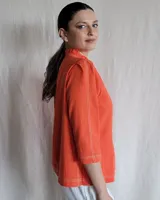 Camisa color beige claro con cuello con volados y mangas 3/4 abullonadas.