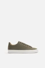 Zapatillas urbanas color verde oliva con cordones, suela blanca y forro interior color beige.