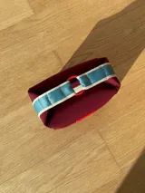 Neceser color beige de forma rectangular, con cierre superior y asa de mano.