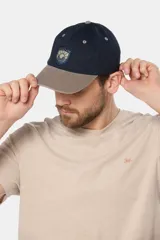 Gorro con visera de lona color azul con visera color beige y parche tejido con logo de la marca.