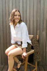 Camisa blanca de lino, de corte clásico, con cuello camisero, manga larga y bolsillo en el pecho.