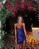 Vestido corto con estampado de mariposas azules y negras, escote en V con volantes y tirantes finos.