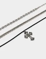 Set de tres chokers plateados y negro. Incluye un choker de cordón negro con dije de cruz plateada, un choker de cadena gruesa plateada y un choker de cadena fina plateada.