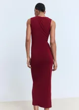 Vestido midi color borgoña, de corte ajustado, sin mangas y con detalle drapeado en el lateral. Presenta un adorno dorado en el hombro.