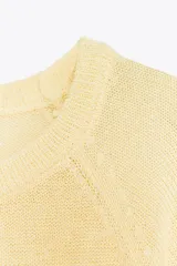 Jersey marrón de punto con cuello redondo y mangas anchas hasta el codo.