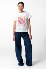 Remera blanca de algodón con cuello redondo y mangas cortas. Estampado frontal con rayas verticales rojas y texto "Sea Sun" con apliques brillantes y flores.