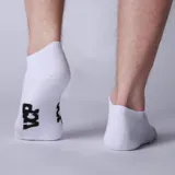 Medias invisibles blancas con logo negro en el tobillo. Ideales para usar con zapatillas y mantener un look discreto.