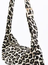 Cartera bandolera con estampado animal print en tonos grises y negros. Tiene correa corta ajustable con hebilla dorada y cierre superior con cremallera dorada.