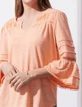 Blusa color celeste con escote en V, mangas largas acampanadas con detalle de crochet y frunces en los hombros.