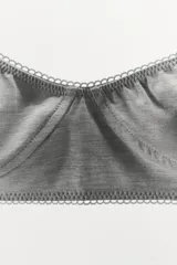 Bralette gris confeccionado en mezcla de viscosa, con escote redondo, tirantes finos ajustables y detalle de costuras marcadas con acabados en ondas. Cierre en espalda con ganchos metálicos.