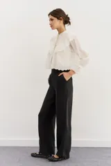 Pantalón sastrero negro de calce recto, con cierre y botón con pretina, bolsillos laterales y trasero.