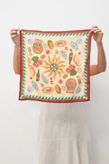 Pañuelo cuadrado pequeño de seda estampada con motivos marinos en tonos beige, celeste, marrón y verde.
