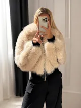 Campera corta de piel sintética color beige con cuello amplio, cierre frontal con cremallera y forro interior.
