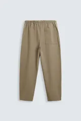 Pantalón verde militar de corte carrot fit, confeccionado en tejido de algodón. Cuenta con cintura elástica ajustable con cordón, bolsillos frontales y un bolsillo trasero de plastrón.