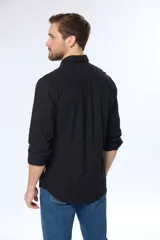 Camisa de lino color beige, de manga larga, con cuello clásico y bolsillo en el pecho.