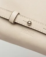 Cartera al hombro en cuero liso satinada, color beige, con cadena y detalles de remaches.