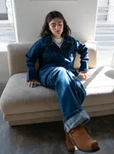 Conjunto de jean azul marino oscuro, compuesto por una chaqueta de corte holgado y un pantalón de tiro medio-bajo con corte vertical.