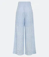 Pantalón largo de tela laise color celeste con textura de florcitas y calados. Tiene corte ancho, bolsillos laterales y cierre invisible.