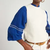 Chaleco de punto color crema.