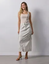 Falda larga color beige, de corte recto, con bolsillos cargo laterales y traseros.
