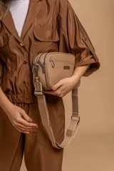 Bandolera color mostaza de simil cuero, con tres cierres principales, cierre delantero y bolsillo trasero. Incluye correa ajustable.