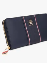 Billetera grande con cremallera Tommy Hilfiger, color azul marino, con insignia dorada con el monograma TH en la parte delantera y detalle de tejido trenzado.