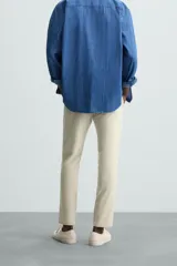 Pantalón largo de vestir gris claro con estampado de cuadros, corte slim fit y cintura elástica. Confeccionado en tejido con alta elasticidad, bolsillos frontales y cierre frontal con cremallera y botón.