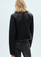 Chaqueta negra de cuero sintético con cuello de piel sintética gris, cierre cruzado con cremallera y bolsillos laterales con cremallera.