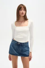 Remera blanca de manga larga y corte ajustado al cuerpo, con escote cuadrado.