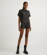Short negro con rayas verticales blancas y estampado de Tom y Jerry en colores.