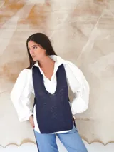 Chaleco de punto azul con escote en U pronunciado y laterales abiertos.