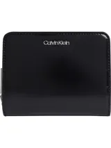 Billetera negra de charol sintético con cierre de cremallera y logo plateado de Calvin Klein en el frente.