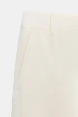 Pantalón capri color verde militar confeccionado en lino, de tiro medio, con bolsillos laterales y traseros. Cierre frontal con cremallera y botón.