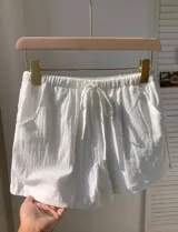 Short blanco de tela rústica con cintura elástica y cordón ajustable.