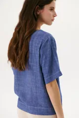 Blusa color crudo de lino con cuello redondo y mangas cortas.