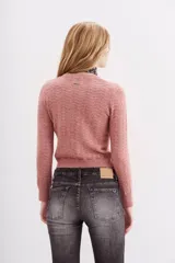 Sweater rosa de tejido calado con lentejuelas, corte ajustado y mangas largas.