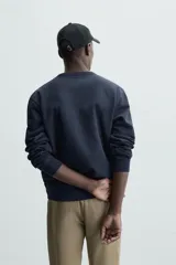 Sudadera azul marino de cuello redondo y manga larga, corte relaxed fit y terminaciones en rib.