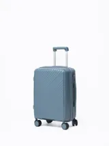 Valija rígida color celeste con diseño de líneas diagonales en el frente. Tiene manija retráctil superior, manija lateral, cuatro ruedas con giro de 360° y candado de seguridad.