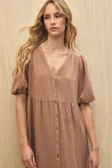 Vestido midi color marrón claro, con escote en V, mangas cortas abullonadas, botones frontales y falda con volantes.