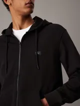 Buzo negro con capucha y cierre frontal, bolsillos laterales y logo de la marca en el pecho.