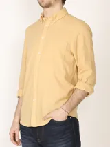 Camisa azul marino de lino y algodón, con cuello abotonado, manga larga con puños enrollados, bolsillo de parche en el pecho y cierre frontal con botones.