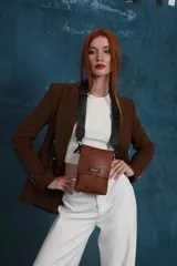 Bandolera tipo phone bag pequeña, color marrón claro, con correa de galón regulable. Tiene un compartimento principal y un bolsillo adicional con tapa.