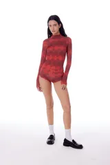Polera de lycra roja con estampado de rombos negros, cuello alto y mangas largas.