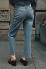 Jeans tobilleros de tiro alto, corte recto, color azul denim con cinco bolsillos y cierre frontal con cremallera y botón metálico.