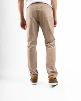 Pantalón de gabardina color beige, de corte recto, con bolsillos laterales y traseros. Se ajusta a la cintura con cinturón de cuero marrón.