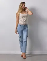 Pantalón jean celeste con bolsillos cargo laterales, pretina con pasadores, botón y cierre.