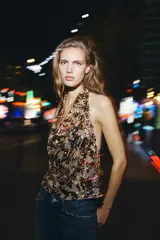 Top de cuello halter con escote fluido y espalda descubierta con tiras a contraste, cubierto de lentejuelas doradas.