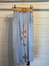 Pantalón palazzo celeste con estampado floral, cintura elástica y cinturón de soga con hebilla circular de madera.