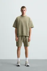 Sudadera relaxed fit color crudo confeccionada en tejido interlock de algodón con elasticidad, cuello redondo, manga corta y bajo acabado en rib.