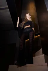 Conjunto negro de pantalón palazzo de tiro alto con cintura elastizada y poncho corto con mangas amplias.